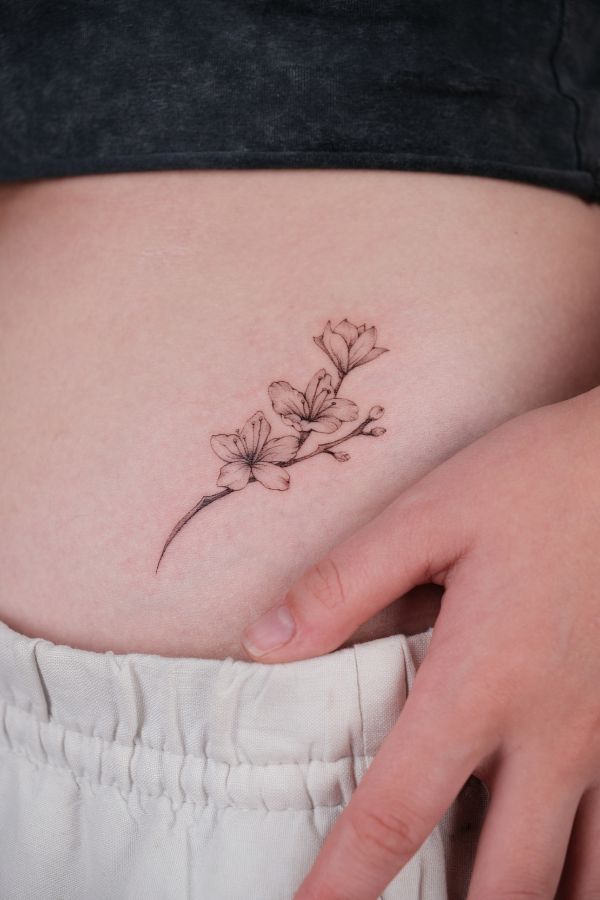 Cherry blossom fine line tattoo on skin, minimalist floral tattoo at 3 Of Spades Tattoo Hanoi