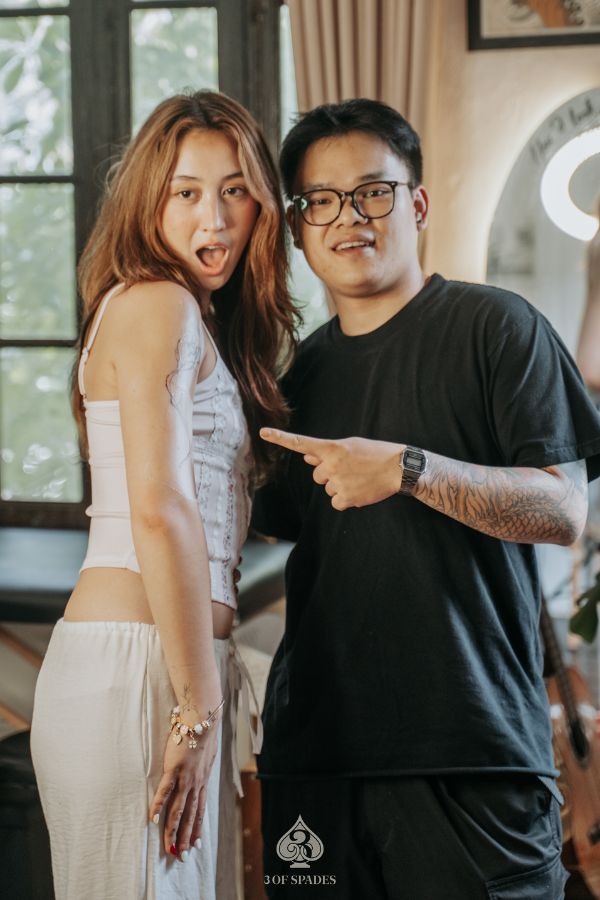 Smiling tattoo client posing with artist at 3 Of Spades Tattoo Studio in Hanoi, showing excitement after getting a new tattoo.