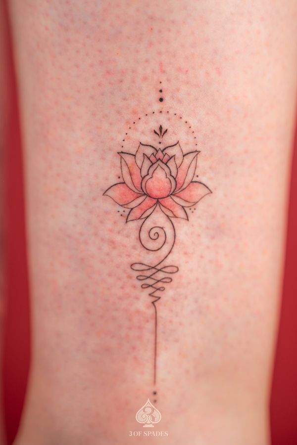 Fine line lotus and unalome tattoo in soft pink tones, symbolizing spiritual journey and inner peace.