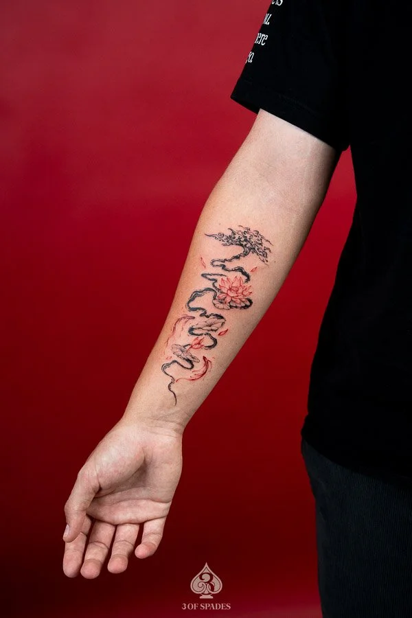 Abstract Tree and Red Lotus, Koi Fish Tattoo featuring flowing black tree branches, vivid red lotus flowers, and elegant koi fish imagery at 3 of Spades Hanoi Tattoo.
