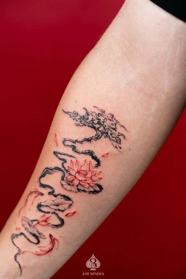 Abstract Tree and Red Lotus, Koi Fish Tattoo featuring flowing black tree branches, vivid red lotus flowers, and elegant koi fish imagery at 3 of Spades Hanoi Tattoo.