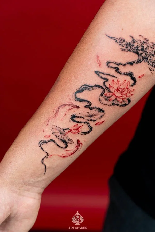 Abstract Tree and Red Lotus, Koi Fish Tattoo featuring flowing black tree branches, vivid red lotus flowers, and elegant koi fish imagery at 3 of Spades Hanoi Tattoo.