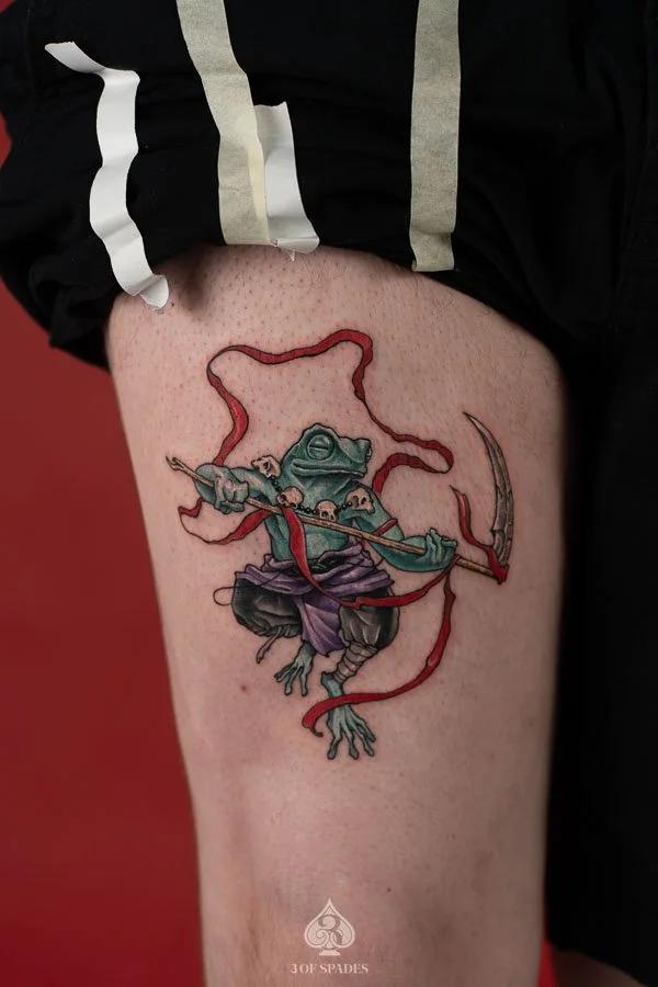 Color Frog Thigh Tattoo concept featuring a colorful frog with expressive eyes, vibrant amphibian markings, and detailed artistic shading at 3 of Spades Hanoi Tattoo.
