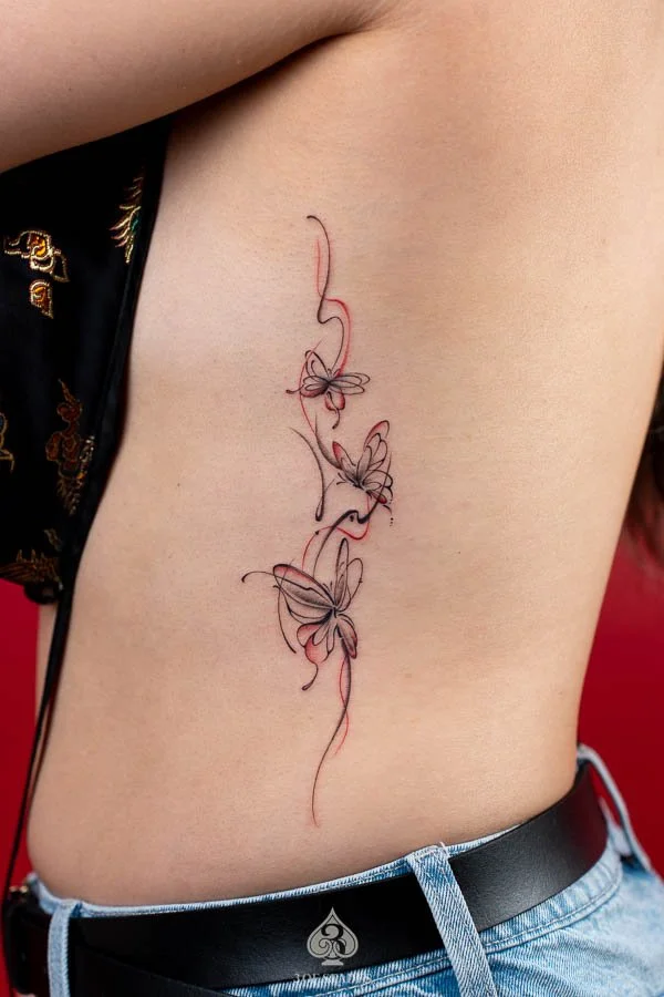 Fine Line Red Butterflies Tattoo featuring delicate red butterfly outlines, elegant wing details, and minimalist linework at 3 of Spades Hanoi Tattoo.
