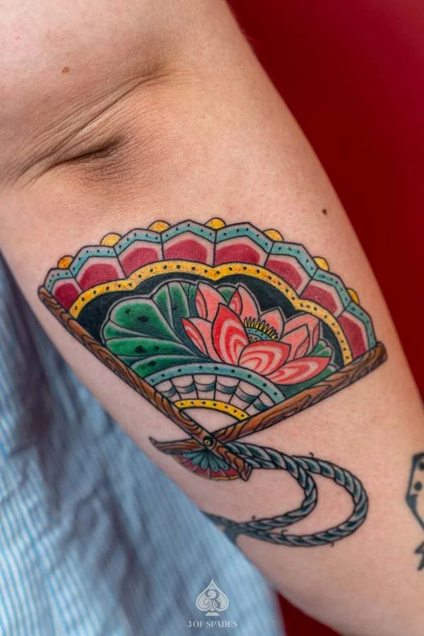 Oldschool Tattoo | Oldschool Lotus Fan Tattoo featuring bold traditional outlines, lotus flowers, and an ornamental hand fan at 3 of Spades Hanoi Tattoo.