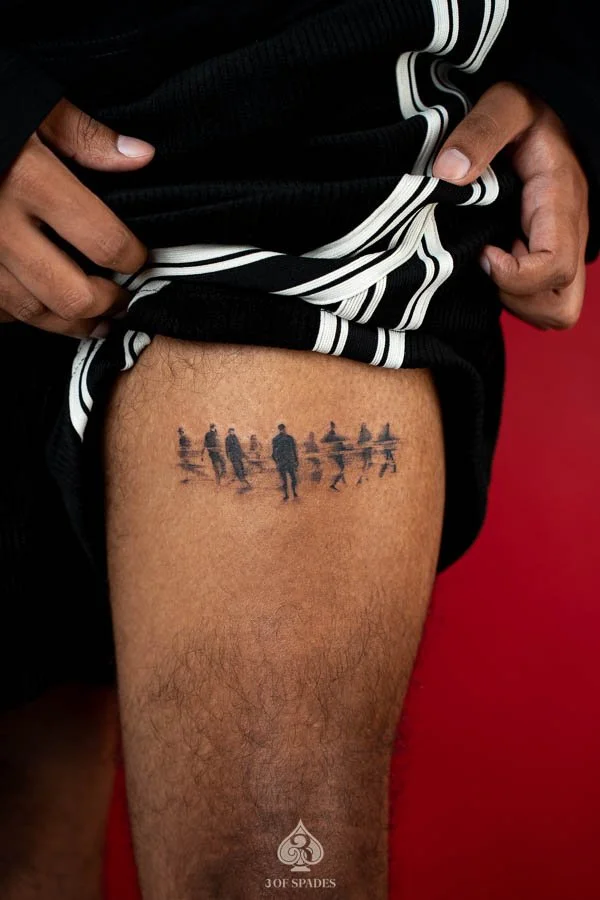 Sonder People Thigh Tattoo concept featuring miniature walking human silhouettes, scattered figures, and soft grey shadows in a minimalist black and grey composition.