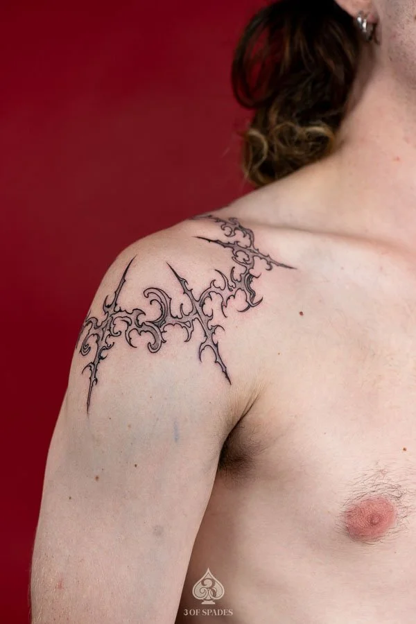 Gothic Tattoo on Shoulder by Hukk featuring sharp symmetrical ornamental linework and abstract black ink details at 3 of Spades Hanoi Tattoo.