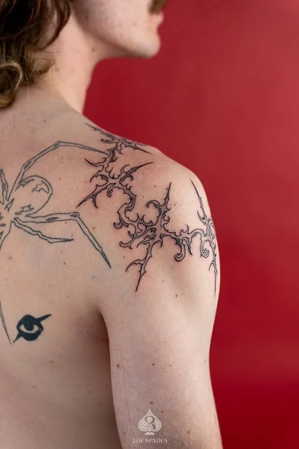 Gothic Tattoo on Shoulder by Hukk featuring sharp symmetrical ornamental linework and abstract black ink details at 3 of Spades Hanoi Tattoo.