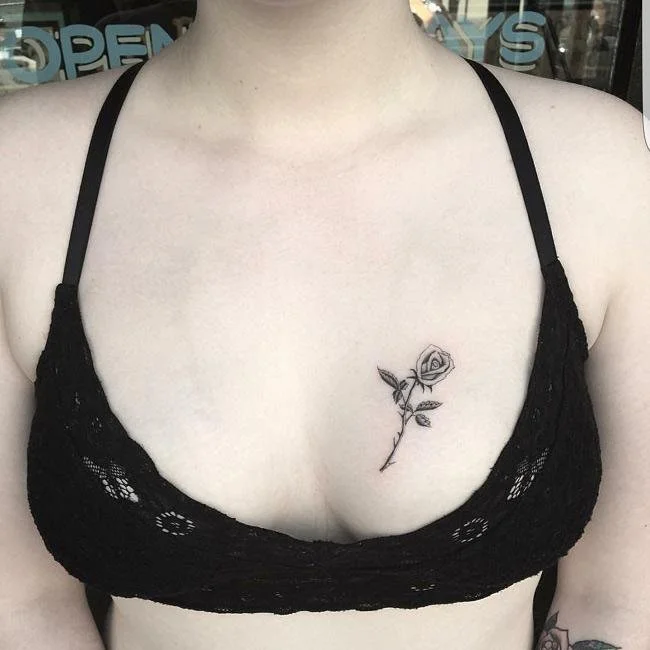 small rose breast tattoo