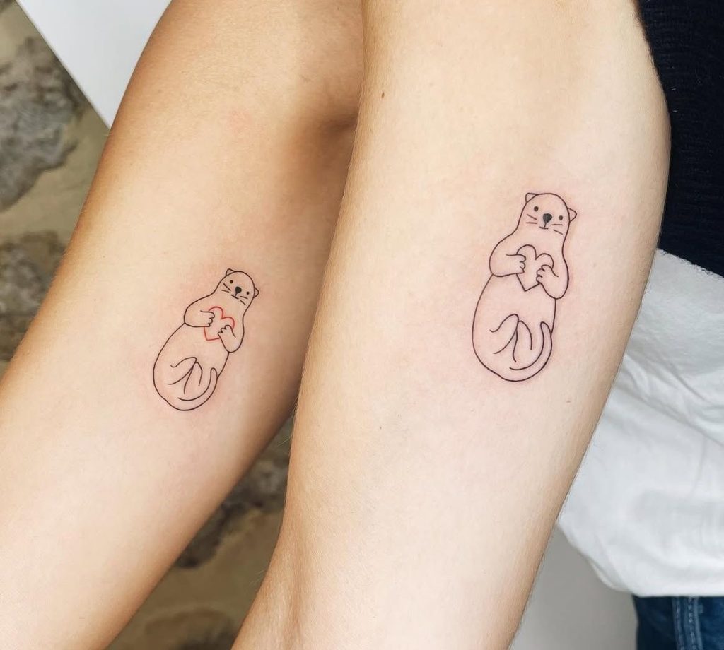 matching sea otters couple tattoo