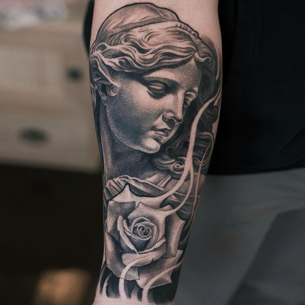 black and grey statue realism tattoo